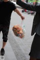 A man in a suit and a woman in a face mask holding a bag of food.