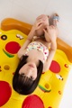 A little girl laying on top of an inflatable pizza.